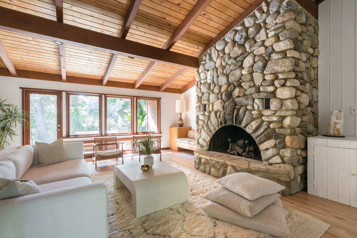 Stone fireplace wooden ceilings Topanga home white Moroccan beni ourain rug