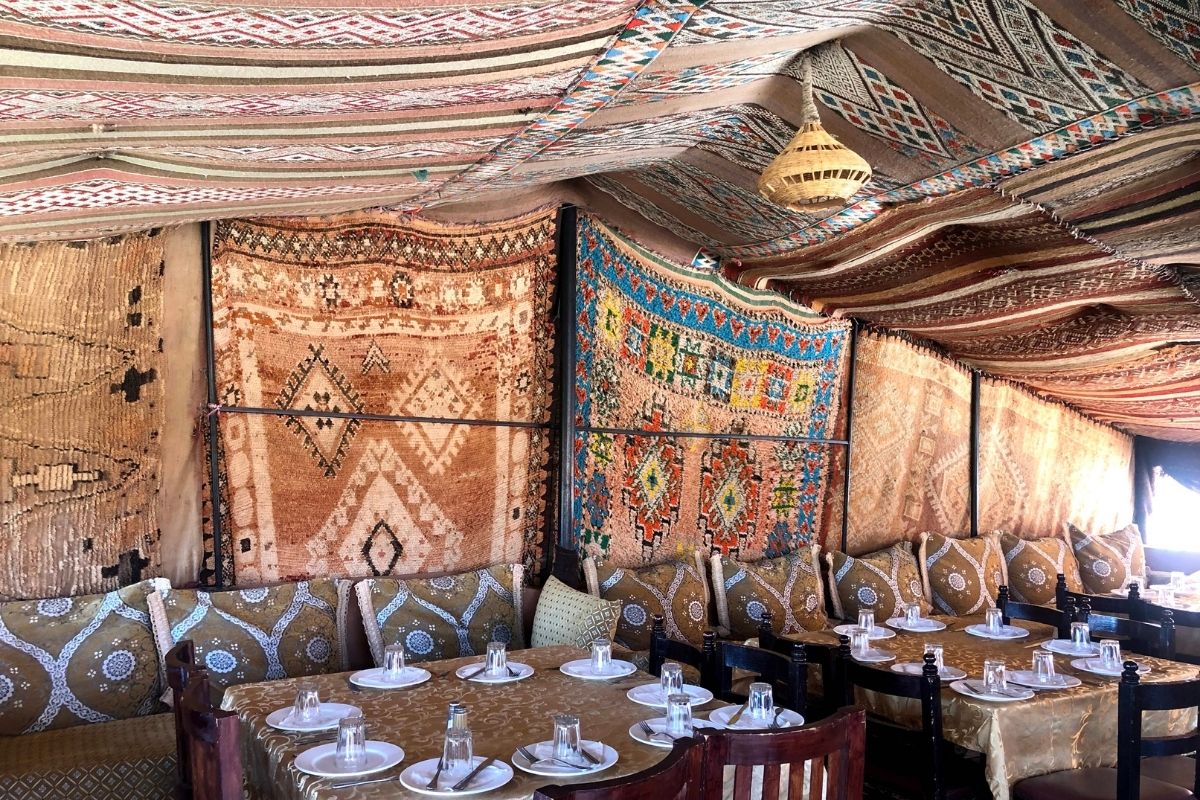 Smithsonian Journeys Splendors of Morocco Tour in Ait Ben Haddou at a restaurant with rugs on the ceiling and walls like a rug tent