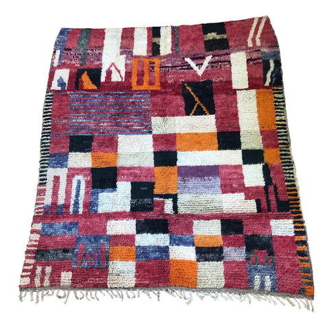Colorful red, purple, and orange blocks on Moroccan rug with abstract and geometric design