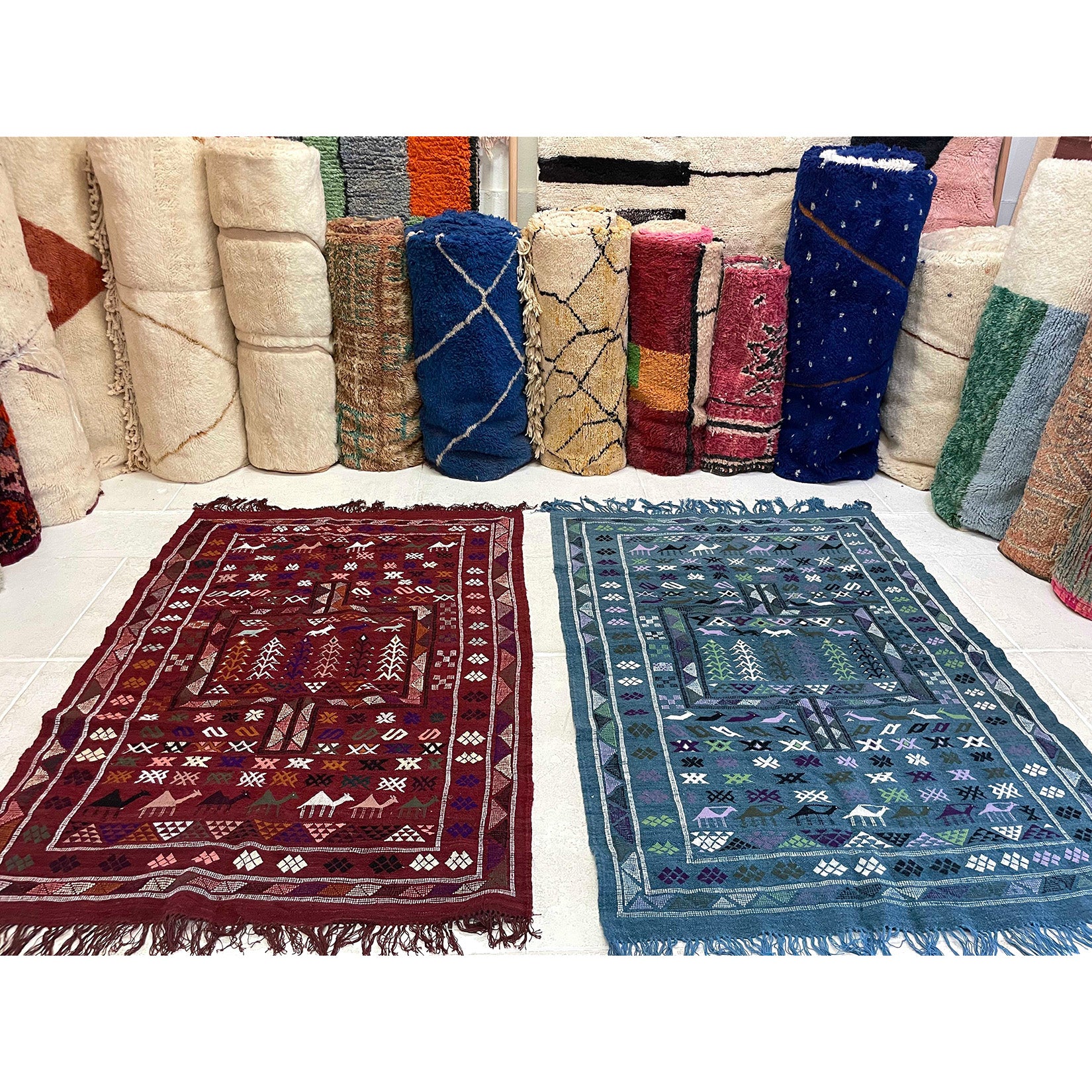 Moroccan kilims at The Rug Shop with bundles of colorful rugs in the background  | Kantara Moroccan Rugs in Los Angeles