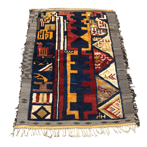 Tribal Moroccan rug with details in red, blue, and mustard yellow