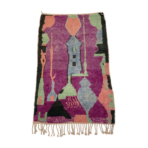 purple and seafoam green abstract moroccan rug with peach, light blue, and black accents