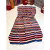 Striped Moroccan blanket crumpled up on a white floor