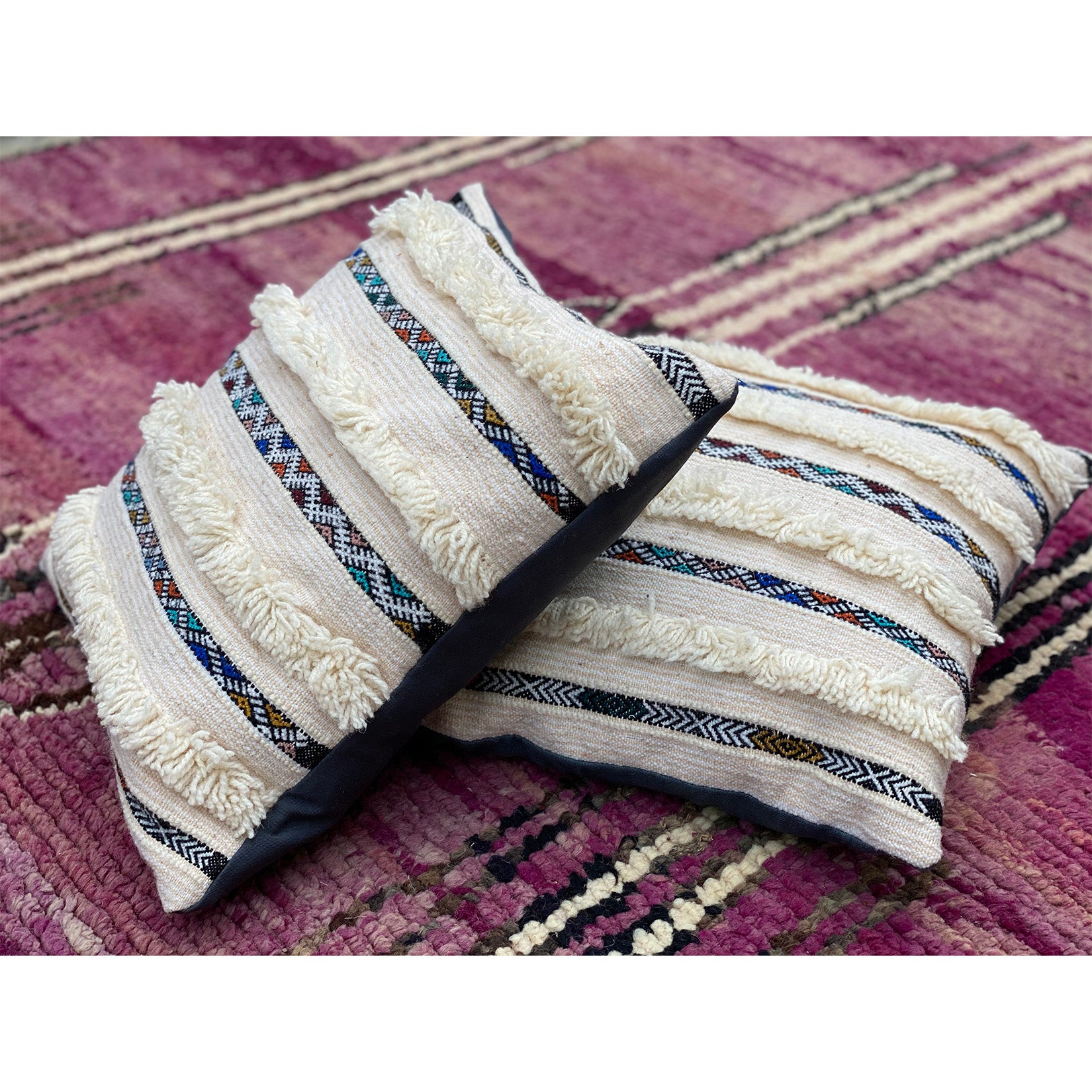 Stack of two modern wedding blanket pillows from Kantara, inspired by handira rugs