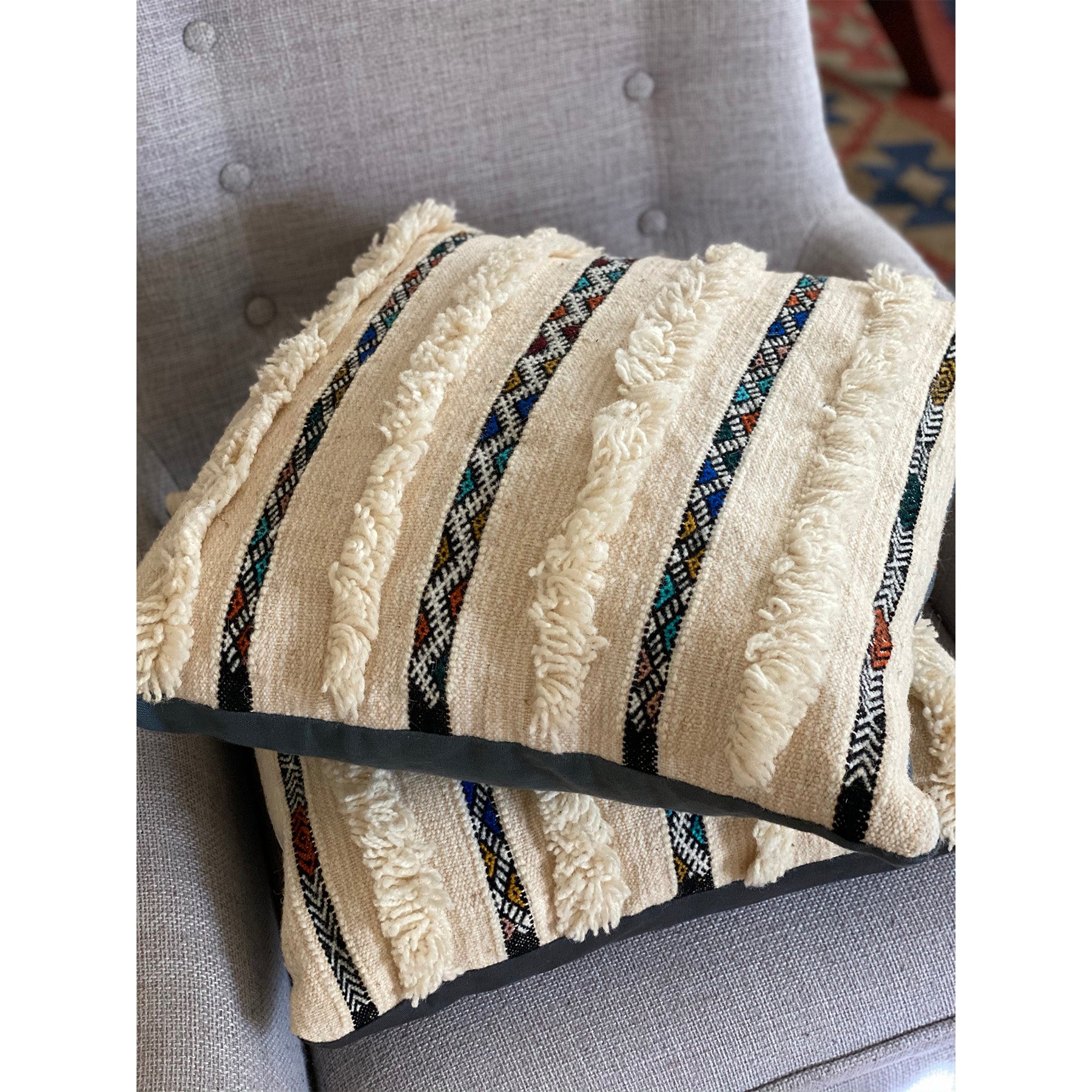 Stack of two colorful wedding blanket pillows in Los Angeles showroom,  made by Kantara artisans