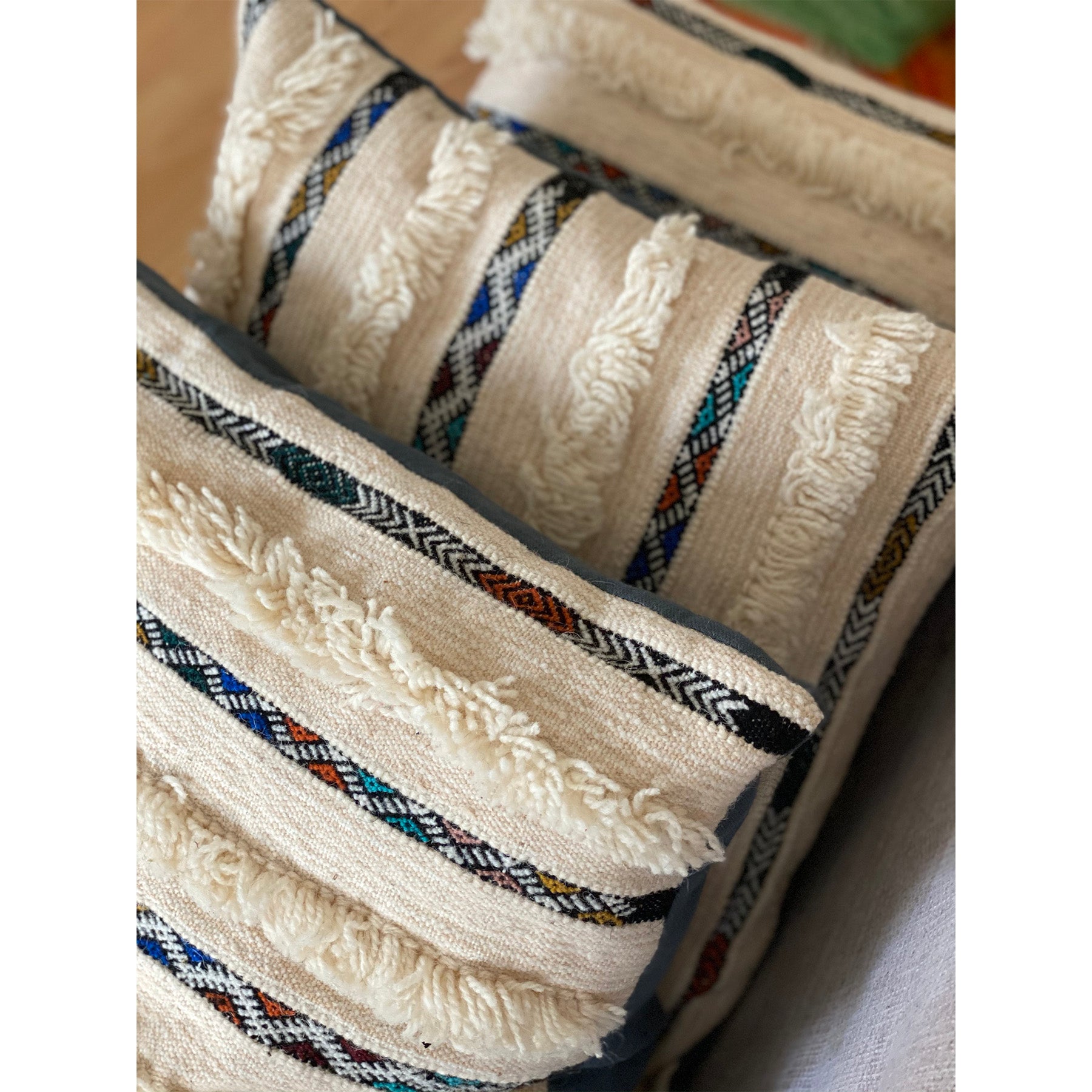 Stack of three colorful Moroccan handira wedding blanket pillows