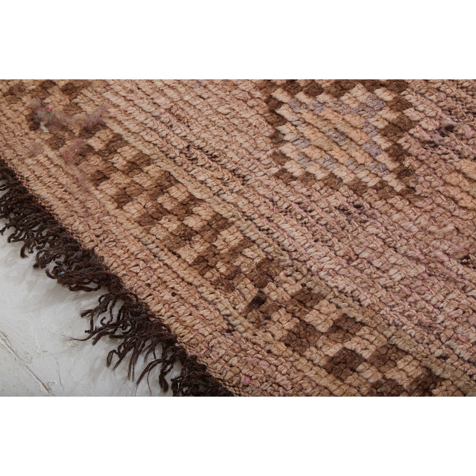 Detail of vintage Moroccan berber rug with brown goat hair fringe