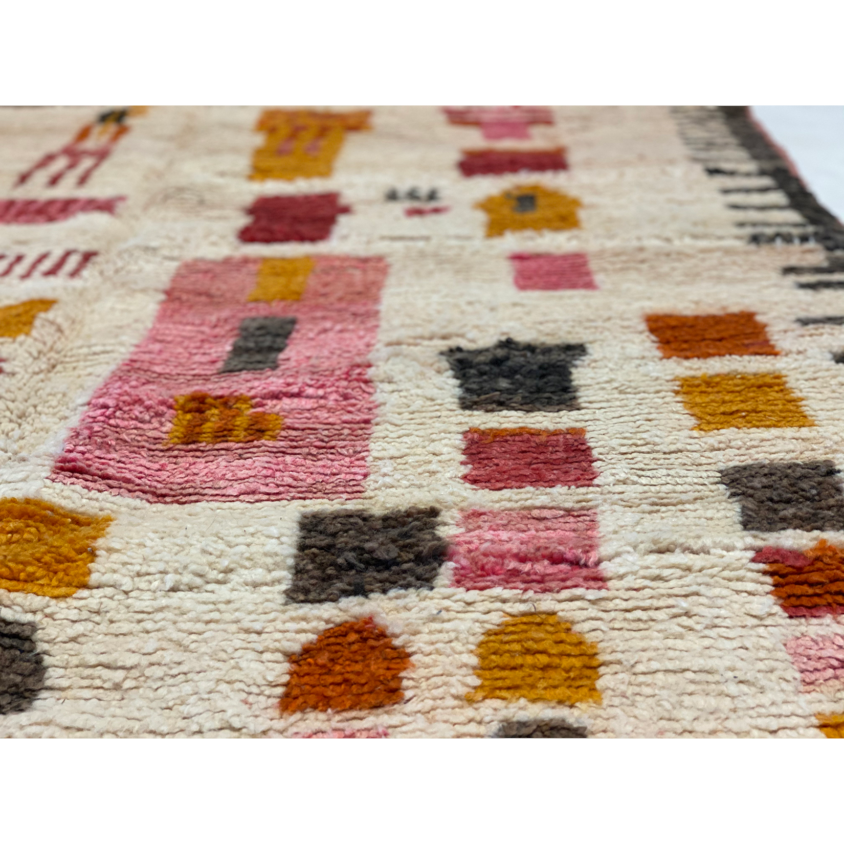 Closeup of Berber carpet for child's nursery in pink and yellow and burnt orange details