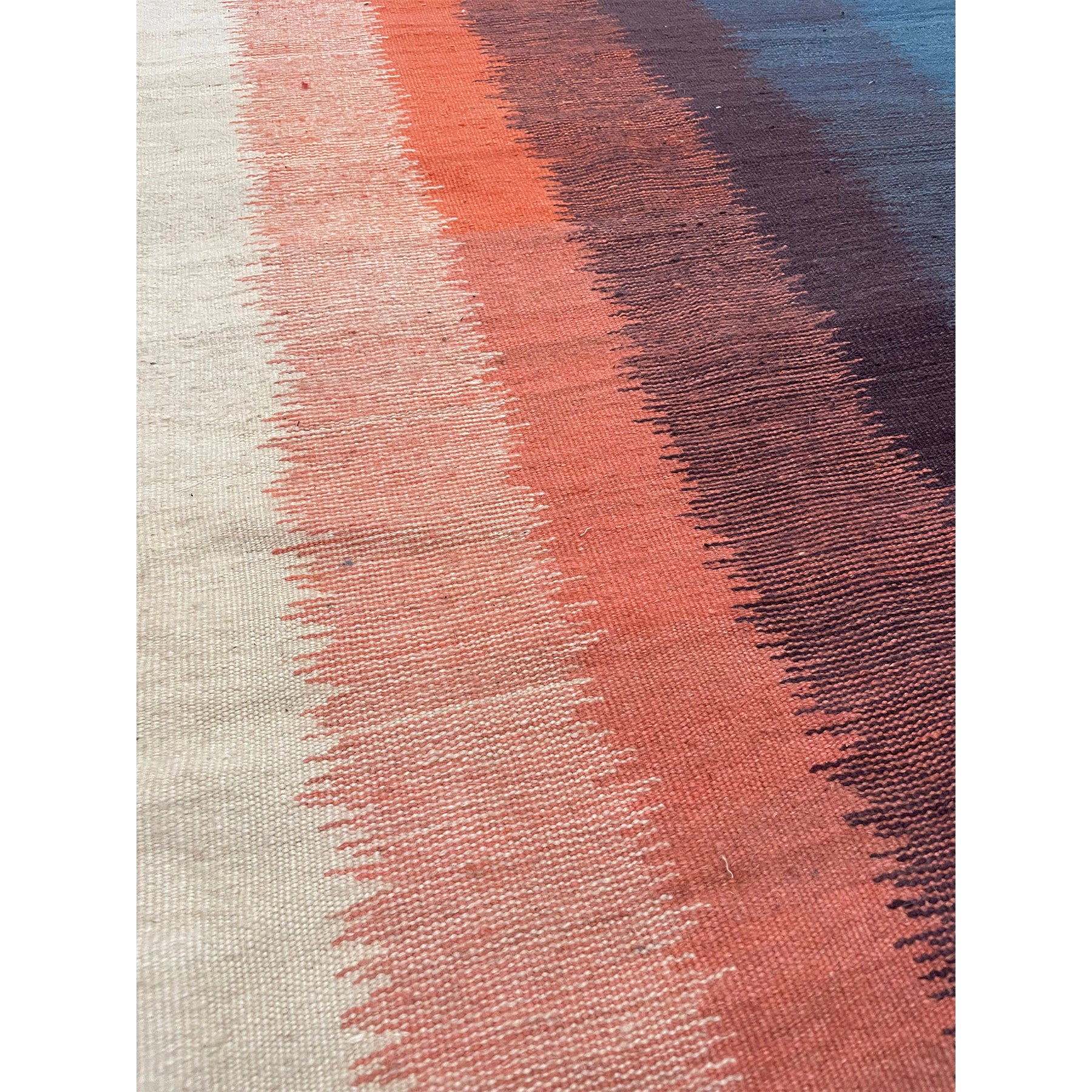 Closeup shot of this Moroccan runner rug with blue purple orange and cream vertical bands of color