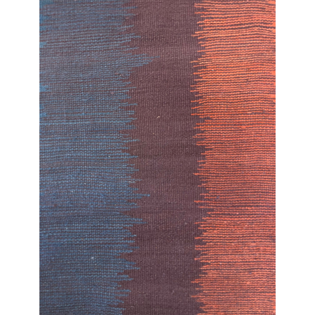 Closeup shot of this Moroccan runner rug with blue purple orange and cream vertical bands of color