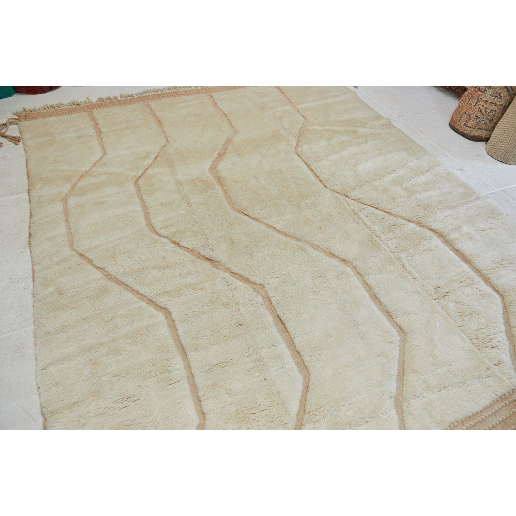 Full Beni Mrirt neutral rug with line details that are inset into the rug in dusty pink and peach tones