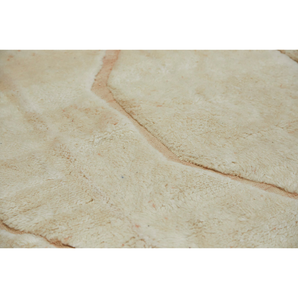 detail of oversized neutral Moroccan beni Mrirt rug where you see texture difference in the rug