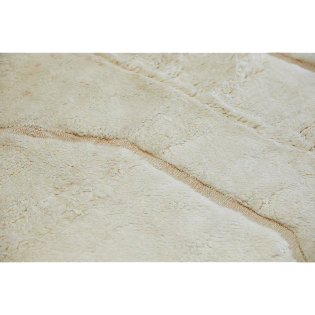 Close up of neutral Moroccan Beni Mrirt rug with plush white wool
